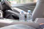 Two full bottled water inside the car's cup holders.